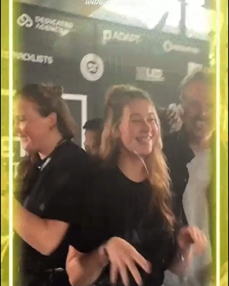 Bezoekers dansen in de booth op Amsterdam Dance Event, voor een perswand met sponsorlogo’s