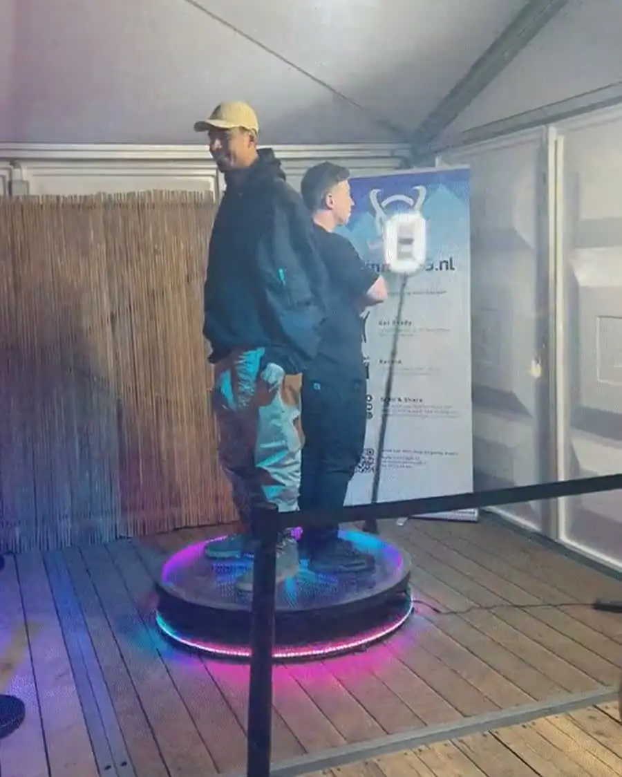 Twee gasten op het plateau van de videobooth, in een tent op een evenement van Afrojack