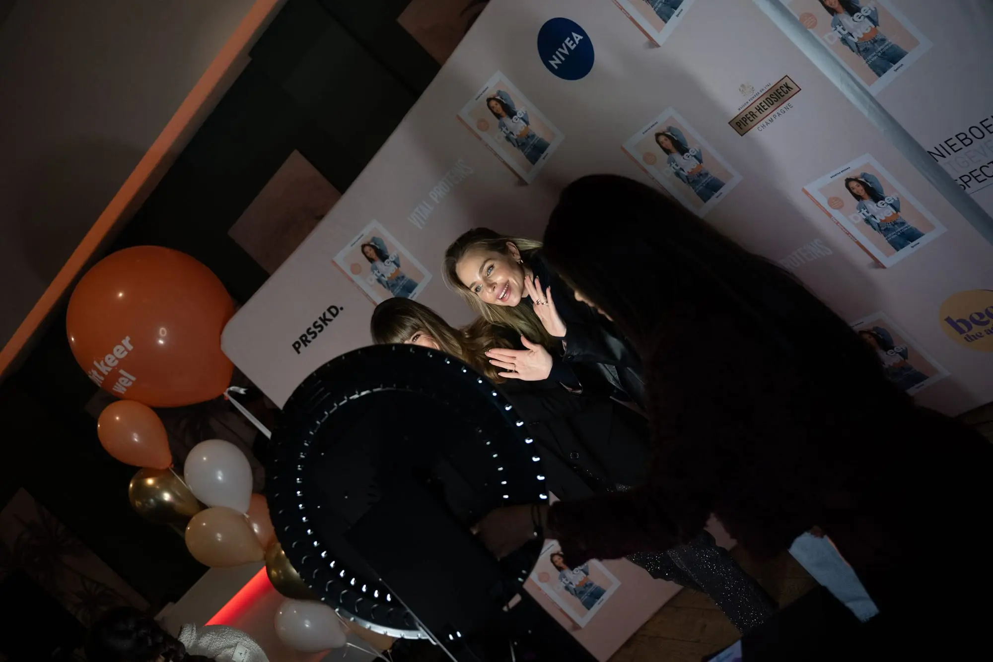Afdrukken opgehangen naast de booth op een perswand