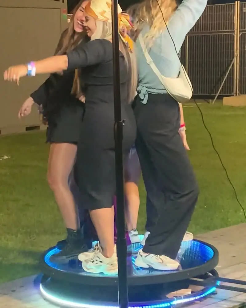 Twee gasten dansen op het plateau van de videobooth, op een festival