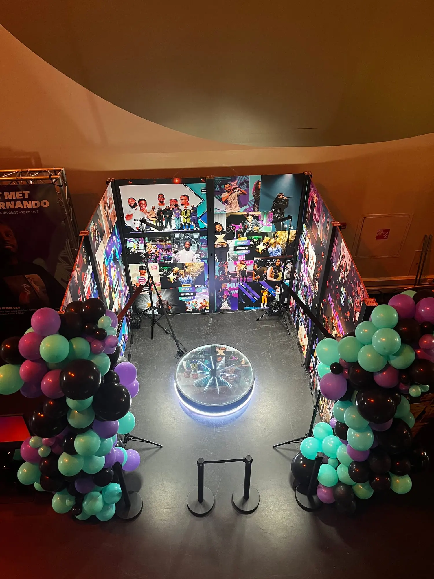 Het plateau van de videobooth van bovenaf, in een tunnel van ledwanden met ballonnen
